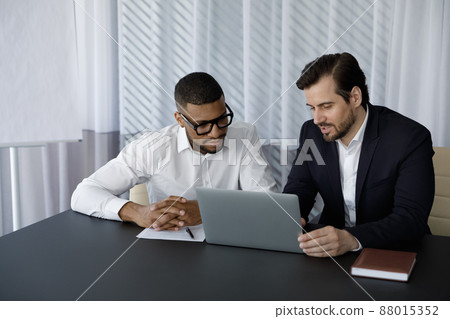 Concentrated two diverse business partners working on computer. 88015352