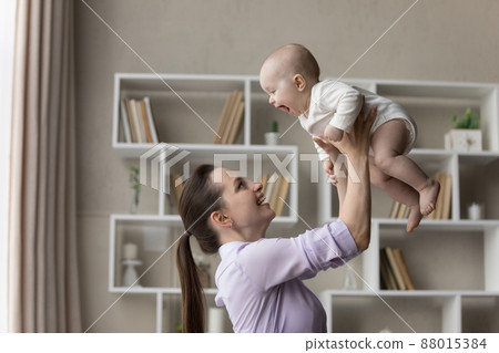 Happy joyful young mom playing with sweet baby Happy joyful young mom playing with sweet baby 88015384