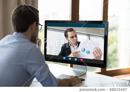 Businessman sit at workplace discuss report with subordinate by videocall 88015487