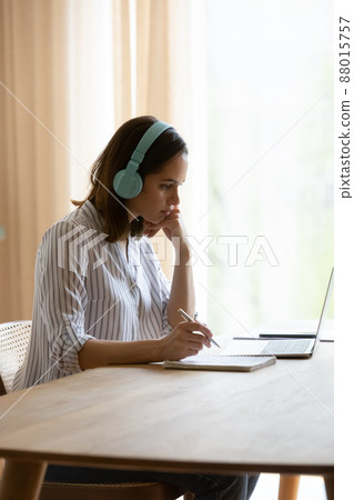 Vertical image woman wear headphones listen audio lesson use laptop Vertical image woman wear headphones listen audio lesson use laptop 88015757
