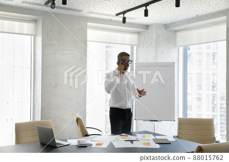 Focused young African American businessman holding phone call conversation. Focused young African American businessman holding phone call conversation. 88015762