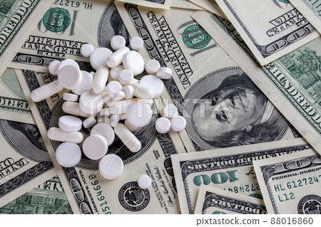handful of white pills on dollar bills close-up handful of white pills on dollar bills close-up 88016860