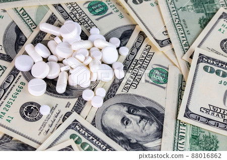 handful of white pills on dollar bills close-up handful of white pills on dollar bills close-up 88016862