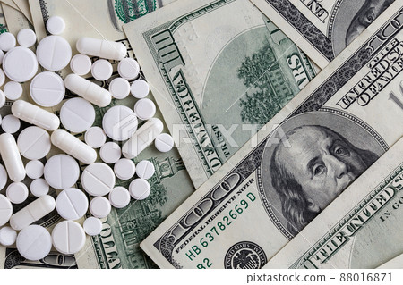 pills flat background, tablets grouped on a us dollar banknotes - flat lay view from above 88016871