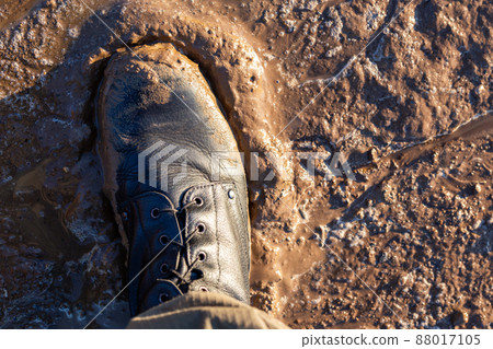 army boot in wet mud closeup top-down vew with selective focus at daylight 88017105