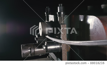 Forge workshop on table. Worker bends the metal rod on the wrought iron round bending machine. Manufacturing of a designer part from a metal rod. Forge workshop on table. Worker bends the metal rod on the wrought iron round bending machine. Manufacturing of a designer part from a metal rod. 88018216