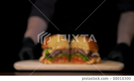 Blur background. Cut craft burger is cooking. Consist sauce salsa, lettuce, red onion, pickle, cheese, chilli green pepper, bun, marbled meat beef. Blur background. Cut craft burger is cooking. Consist sauce salsa, lettuce, red onion, pickle, cheese, chilli green pepper, bun, marbled meat beef. 88018300