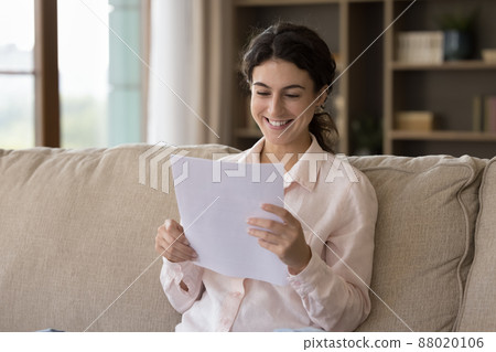 Happy young Hispanic woman reading letter with good news. Happy young Hispanic woman reading letter with good news. 88020106