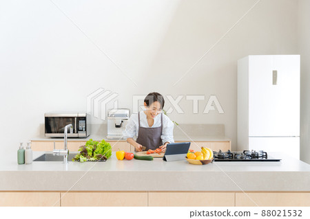 A woman standing in the kitchen 88021532