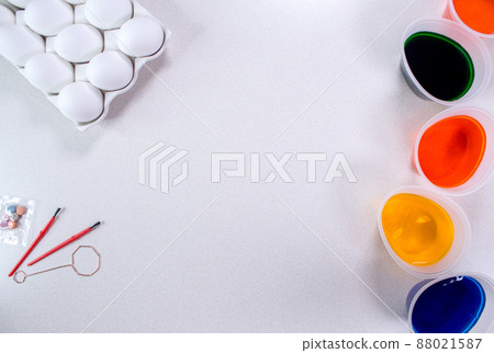 Tools for painting eggs for easter, eggs box, cups of colorful paint, easter eggs, plate, brushes and paints on the table side view Tools for painting eggs for easter, eggs box, cups of colorful paint, easter eggs, plate, brushes and paints on the table side view 88021587