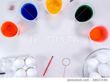 Tools for painting eggs for easter, eggs box, cups of colorful paint, easter eggs, plate, brushes and paints on the table side view 88021588
