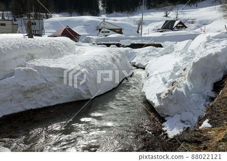The Nunozawa River flows through a wall of snow and a village is buried in remaining snow in Tadami Town, Fukushima Prefecture The Nunozawa River flows through a wall of snow and a village is buried in remaining snow in Tadami Town, Fukushima Prefecture 88022121