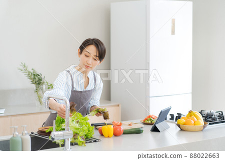 A woman standing in the kitchen 88022663