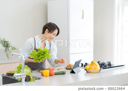 A woman standing in the kitchen 88022664