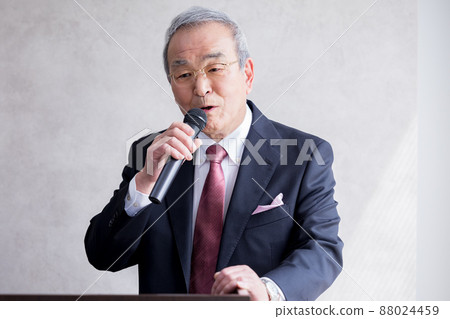 Senior man giving a speech with a business microphone Senior man giving a speech with a business microphone 88024459