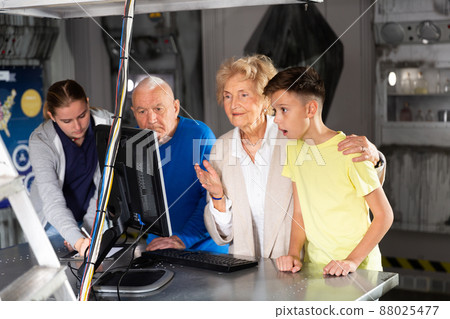Kids and grandparents using computer in escape room 88025477