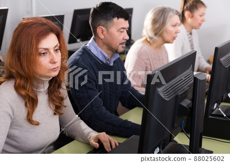 People of different age studying in computer class 88025602