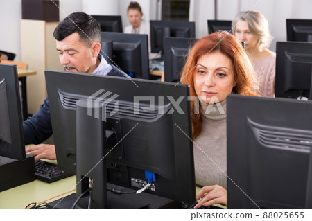 Middle aged woman taking computer lessons 88025655