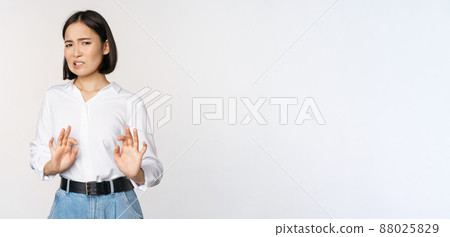 No thank you. Young disgusted asian woman declining proposal, shaking hands and step back, looking with dislike, rejecting offer, standing over white background No thank you. Young disgusted asian woman declining proposal, shaking hands and step back, looking with dislike, rejecting offer, standing over white background 88025829