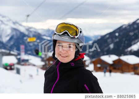 Positive woman in ski helmet and glasses enjoying vacation in ski resort 88025865