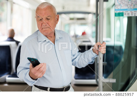 Senior European with smartphone man in tram 88025957