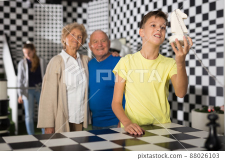 Kids solving riddles in escape room and grandparents watching them 88026103