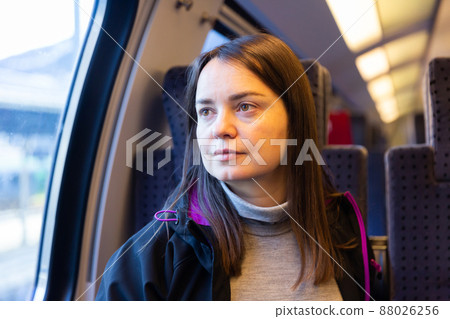 Woman sitting on her seat while traveling by train Woman sitting on her seat while traveling by train 88026256