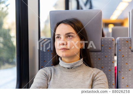Woman sitting on her seat while traveling by train Woman sitting on her seat while traveling by train 88026258