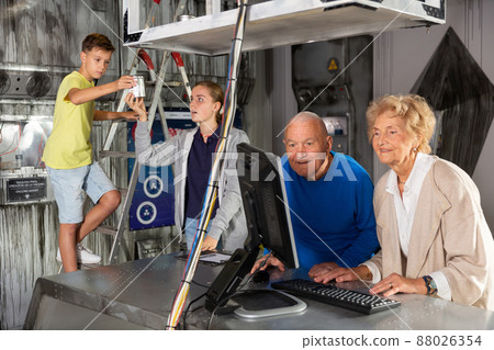 Family is using PC in time having fun together in lost labroom 88026354