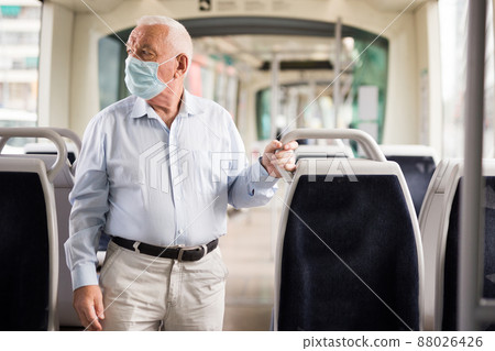 Elderly man standing in tram Elderly man standing in tram 88026426