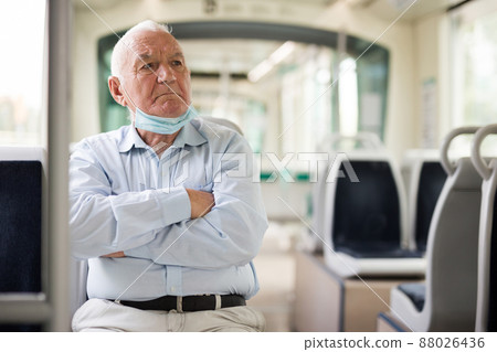 Old man wearing face mask in streetcar Old man wearing face mask in streetcar 88026436