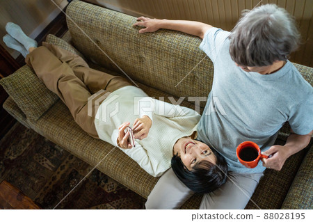 Middle couple relaxing in the living room Middle couple relaxing in the living room 88028195