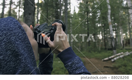 Traveler photographing scenic view in forest. One caucasian woman shooting nice magic look. Girl take photo video on dslr mirrorless camera. Traveler photographing scenic view in forest. One caucasian woman shooting nice magic look. Girl take photo video on dslr mirrorless camera. 88028208
