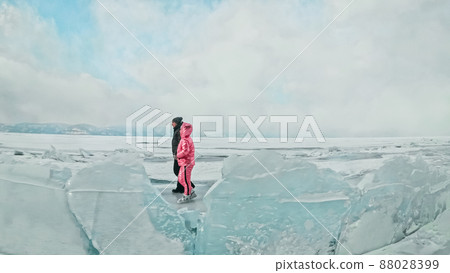 Couple has fun during winter walk against background of ice of f 88028399