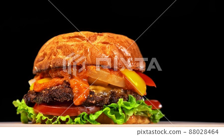 Craft burger is cooking. Consist: red sauce salsa, lettuce, red onion, pickle, cheese, chilli green pepper, air bun and marbled meat beef. 88028464