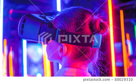 Back view: woman using virtual reality headset at interactive VR exhibition Back view: woman using virtual reality headset at interactive VR exhibition 88029310