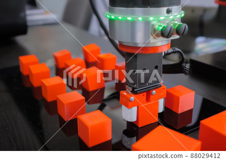Pick and place robotic arm manipulator moving red toy blocks at robot exhibition Pick and place robotic arm manipulator moving red toy blocks at robot exhibition 88029412