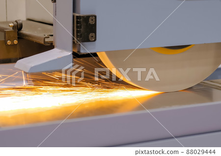 Surface grinding wheel machine working with sheet metal at factory - close up 88029444