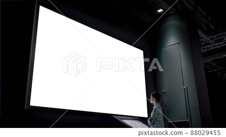 Woman looking at blank large interactive wall display - white screen concept Woman looking at blank large interactive wall display - white screen concept 88029455
