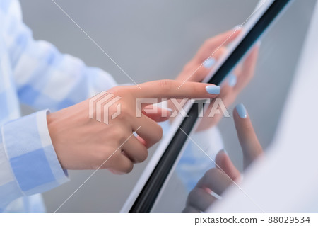 Close up: woman using touchscreen display of interactive kiosk at exhibition Close up: woman using touchscreen display of interactive kiosk at exhibition 88029534