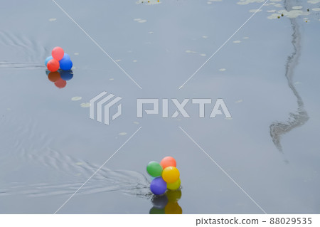 Colorful helium balloons floating in river - water pollution 88029535
