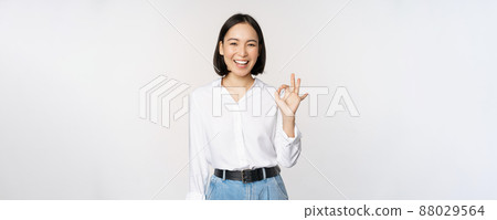 Very good. Smiling asian woman showing okay with satisfied face expression, praise and compliment great job, pleased by smth, standing over white background Very good. Smiling asian woman showing okay with satisfied face expression, praise and compliment great job, pleased by smth, standing over white background 88029564