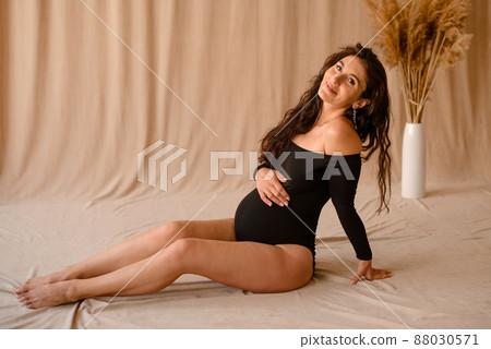 Portrait of the young pregnant woman enjoying her pregnancy Portrait of the young pregnant woman enjoying her pregnancy 88030571