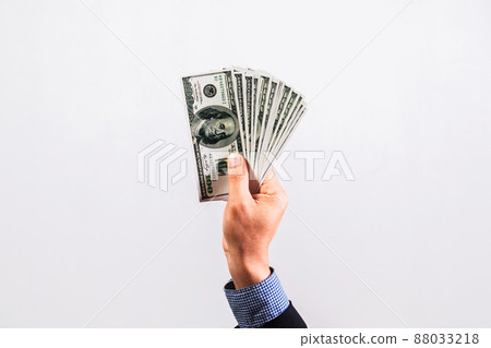 Businessman in suit holding several 100 dollar bills. Finance concept. Businessman in suit holding several 100 dollar bills. Finance concept. 88033218