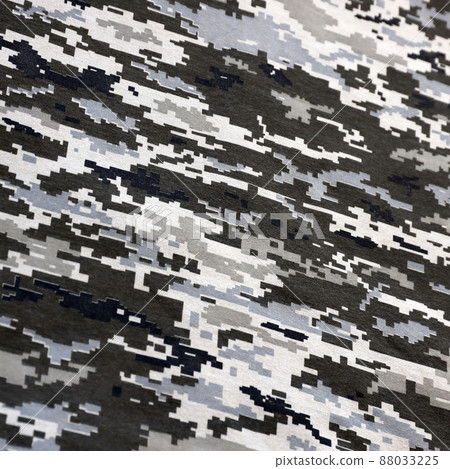 Fabric with texture of Ukrainian military pixeled camouflage. Cloth with camo pattern in grey, brown and green pixel shapes. Official uniform of Ukrainian soldiers Fabric with texture of Ukrainian military pixeled camouflage. Cloth with camo pattern in grey, brown and green pixel shapes. Official uniform of Ukrainian soldiers 88033225