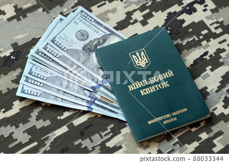 Ukrainian military ID and US dollar bills on fabric with texture of pixeled camouflage. Cloth with camo pattern in grey, brown and green pixel shapes with Ukrainian army personal token. Ukrainian military ID and US dollar bills on fabric with texture of pixeled camouflage. Cloth with camo pattern in grey, brown and green pixel shapes with Ukrainian army personal token. 88033344