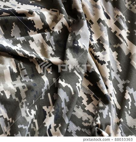 Fabric with texture of Ukrainian military pixeled camouflage. Cloth with camo pattern in grey, brown and green pixel shapes. Official uniform of Ukrainian soldiers Fabric with texture of Ukrainian military pixeled camouflage. Cloth with camo pattern in grey, brown and green pixel shapes. Official uniform of Ukrainian soldiers 88033363
