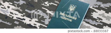 Ukrainian military ID on fabric with texture of pixeled camouflage. Cloth with camo pattern in grey, brown and green pixel shapes with Ukrainian army personal token Ukrainian military ID on fabric with texture of pixeled camouflage. Cloth with camo pattern in grey, brown and green pixel shapes with Ukrainian army personal token 88033387