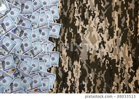 US dollar bills on fabric with texture of Ukrainian military pixeled camouflage. Cloth with camo pattern in grey, brown and green pixel shapes US dollar bills on fabric with texture of Ukrainian military pixeled camouflage. Cloth with camo pattern in grey, brown and green pixel shapes 88033513