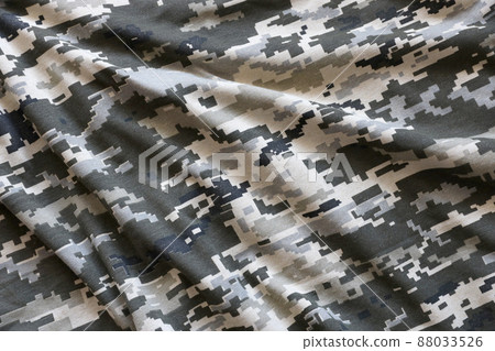 Fabric with texture of Ukrainian military pixeled camouflage. Cloth with camo pattern in grey, brown and green pixel shapes. Official uniform of Ukrainian soldiers Fabric with texture of Ukrainian military pixeled camouflage. Cloth with camo pattern in grey, brown and green pixel shapes. Official uniform of Ukrainian soldiers 88033526